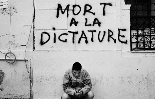 Тунис (Тунис). Демонстрант отправляет сообщение на твиттер или посылает смс.  Январь 2011 года