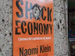 Рекламный плакат «Доктрины шока» у входа в книжный магазин в г. Рапалло (Италия)