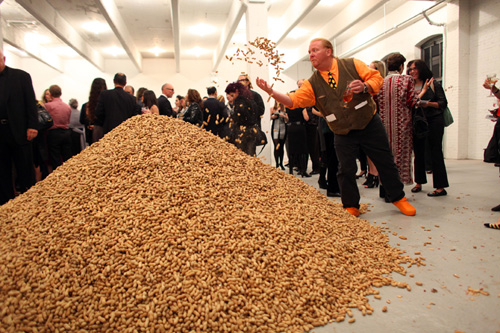Jennifer Rubell, Creation, the Performa 09 Opening Night Benefit Dinner, 2009. Mario Batali throwing peanuts from the one-ton pile of nuts from Bazzini Nuts