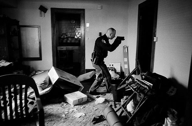 Офицер полиции обходит брошенный дом в Кливленде, штат Огайо