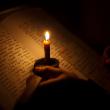 Послушник читает при свете свечи