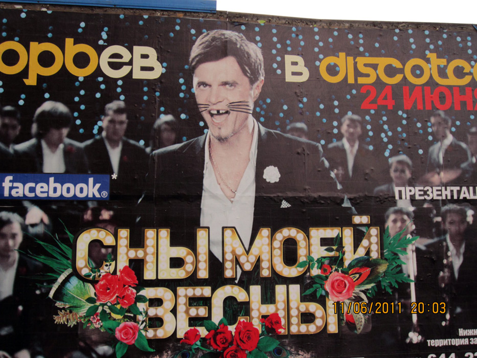 Фотография биллборда с ИГ на Тверской улице с усами и без зуба, свидетельствами народной любви к начинающему артисту.