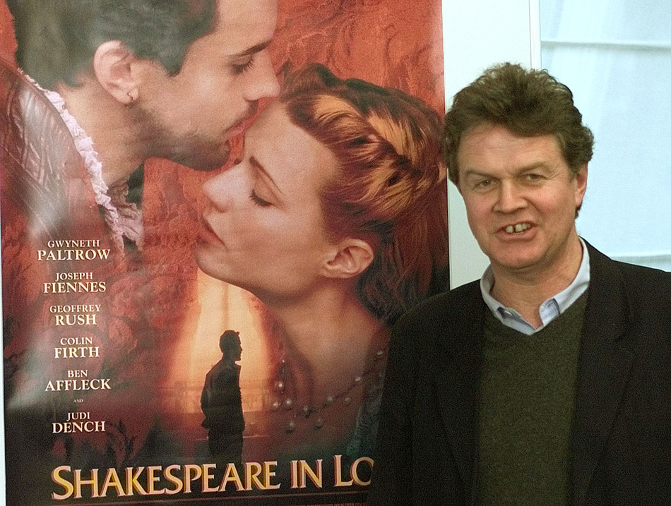 Джон Мэдден позирует на фоне постера к фильму «Влюбленный Шекспир», февраль 1999