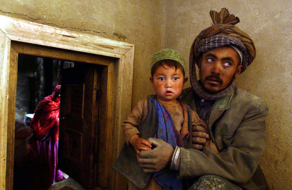 Visa d’or 2002 Тайлер Хикс. Отец держит на руках сына рядом со своим жилищем, Шебарту, Афганистан, 5 декабря 2001 г. 