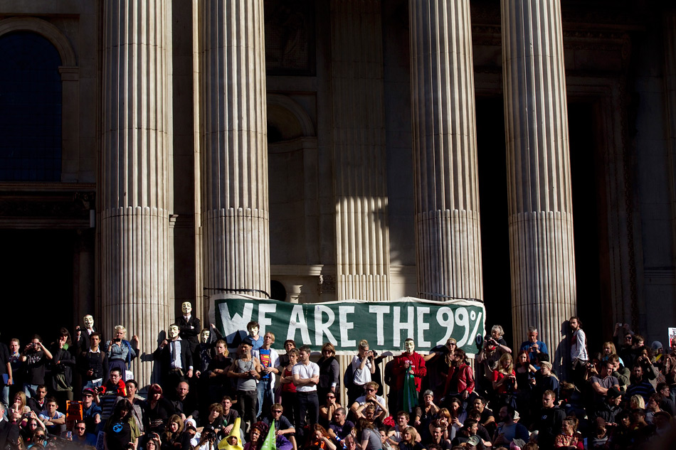 Участники акции протеста держат баннер «99% — это мы» на фоне Собора св. Павла. 15 октября 2011. Лондон, Великобритания