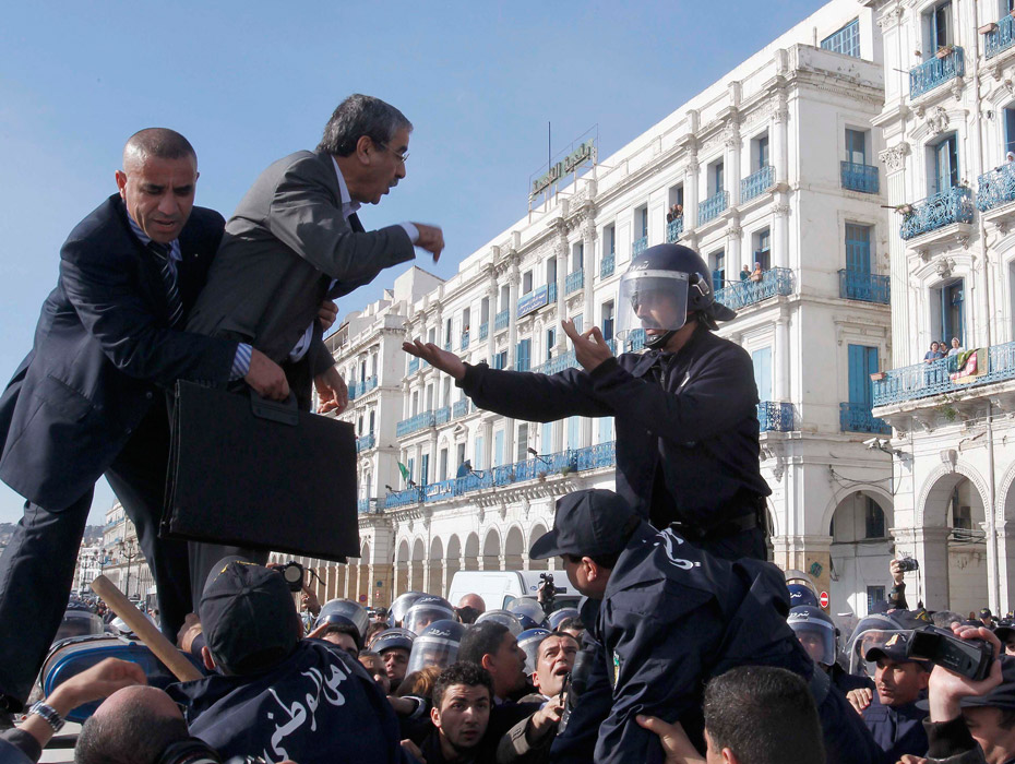 Алжир. Один из лидеров оппозиционного Движения за культуру и демократию (RCD) разговаривает с полицейскими во время антиправительственной демонстрации. 26 февраля 2011 года