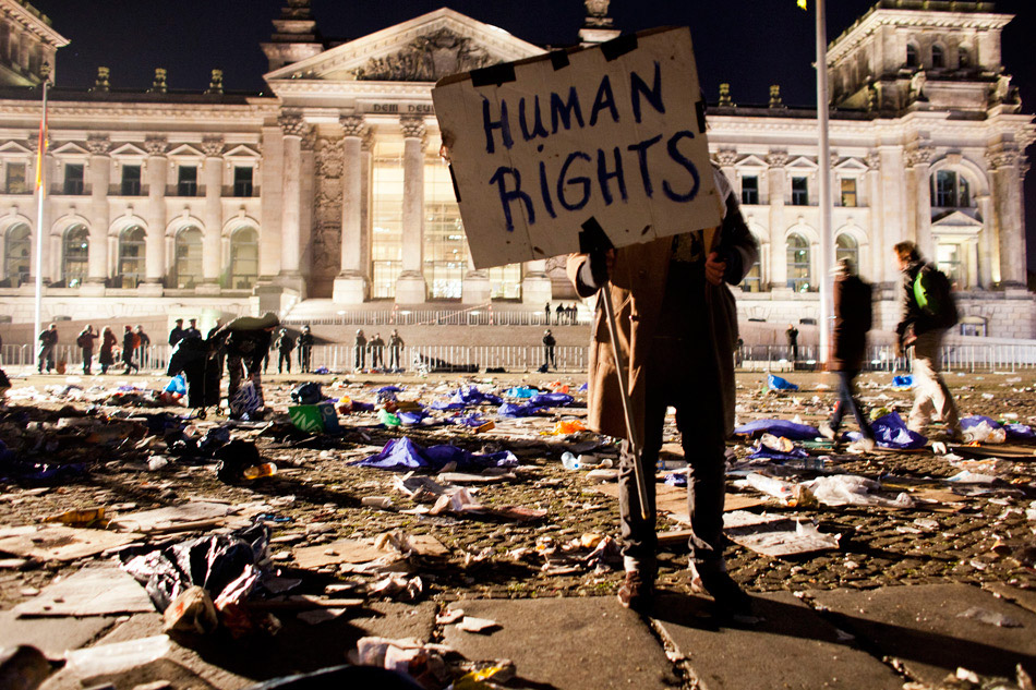 Берлин (Германия). Демонстрант держит баннер после сидячей акции протеста. 15 октября 2011 года