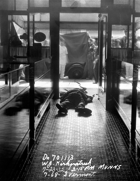 Маннз. Вермонт стрит, 768. Мертвое тело в выложенном плиткой коридоре, где на заднем фоне полицейские поднимают простыню. 1932 