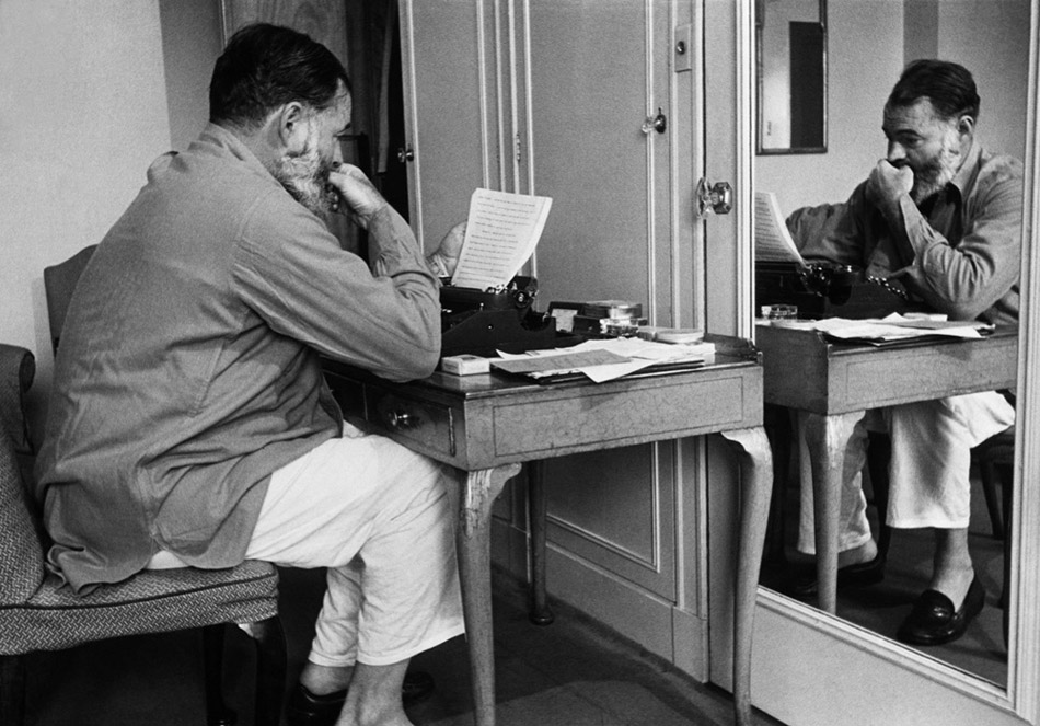 1944. Эрнест Хемингуэй (1899–1961) за пишущей машинкой перечитывает свою статью, написанную в период его работы фронтовым корреспондентом 